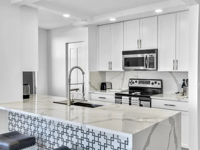 a kitchen with stainless steel appliances a stove sink microwave and cabinets