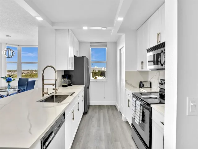 a kitchen with stainless steel appliances granite countertop a sink stove and refrigerator