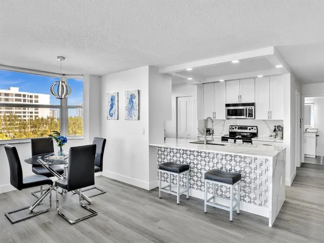 a living room with furniture a dining table and kitchen view with wooden floor