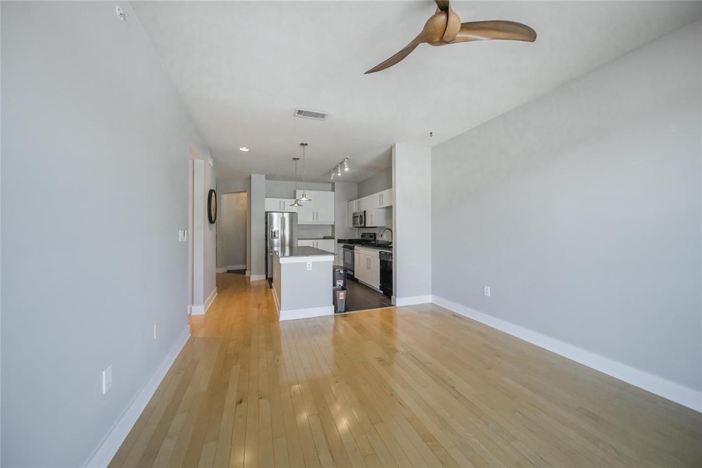 4414 Cedar Springs Road, Unit 214 Dallas, TX 75219 - Photo 12 of 29 Unfurnished living room featuring light wood finished floors and ceiling fan
