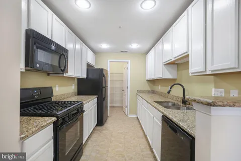 a kitchen with stainless steel appliances granite countertop a stove sink microwave and refrigerator