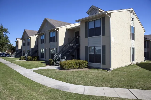 a view of a white house next to a yard