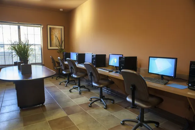 a view of a workspace with furniture and a window