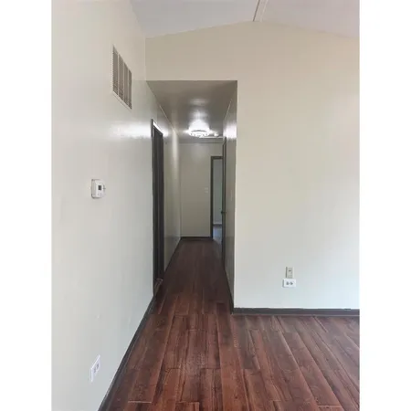 a view of a hallway with wooden floor