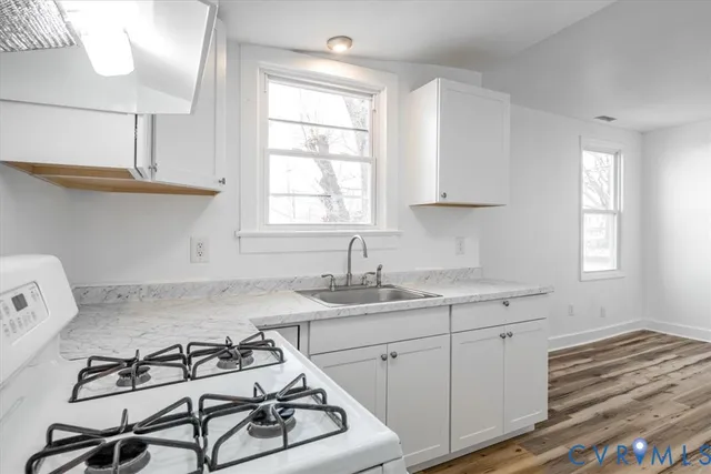 a kitchen with a stove a sink and a window