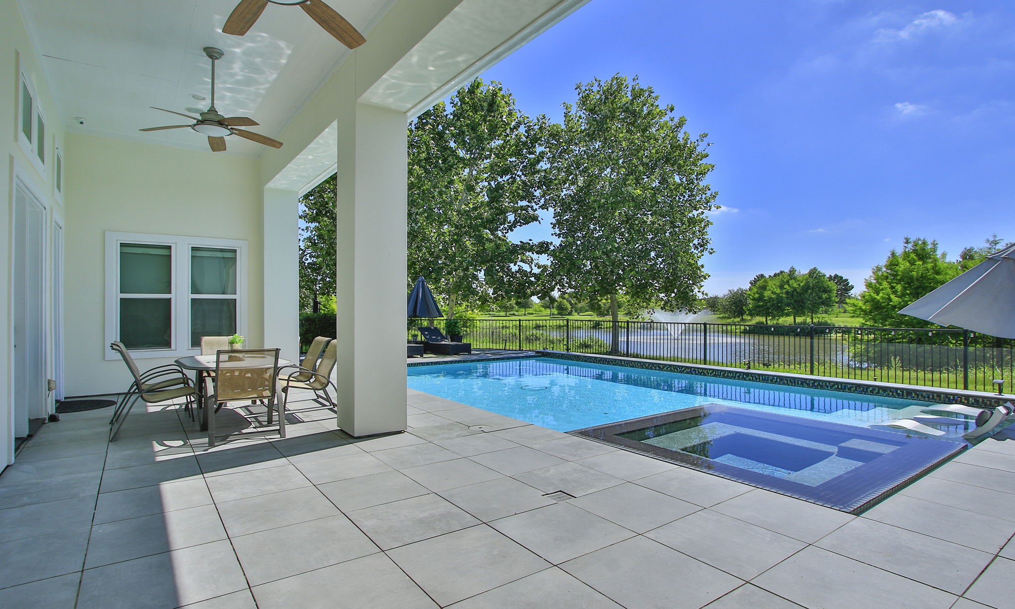 28518 Hoffman Spring Lane Fulshear, TX 77441 - Photo 35 of 50 Spectacular Outdoor Oasis featuring heated pool and spa, several sitting areas and lake views.