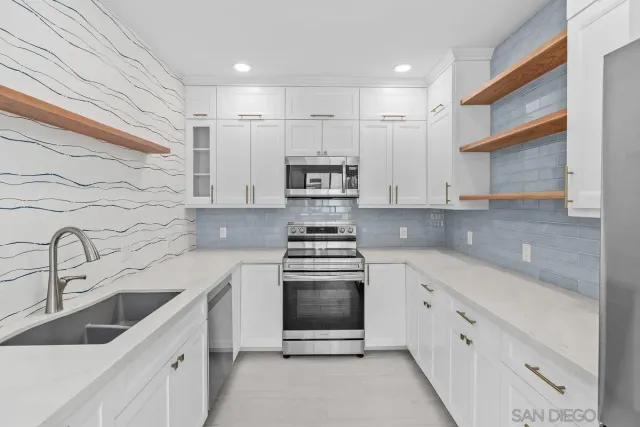 a kitchen with white cabinets and refrigerator