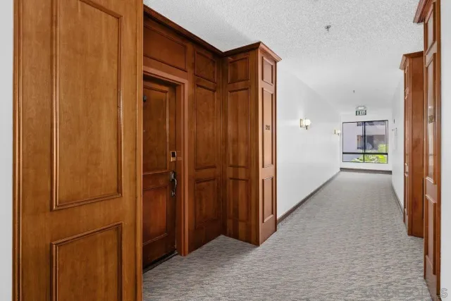 a view of a hallway with wooden cabinets
