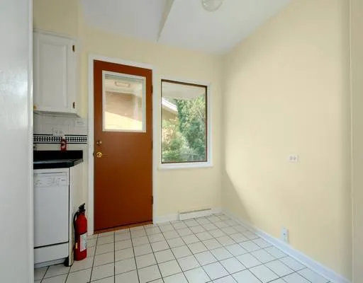 a view of an empty room with window and cabinet