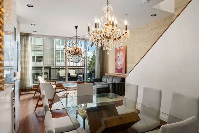 a view of a dining room with furniture a chandelier and wooden floor