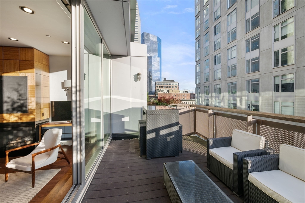 88 Kingston Street, Unit PH7C Boston, MA 02111 - Photo 13 of 31 a kitchen with stainless steel appliances granite countertop a sink and wooden cabinets
