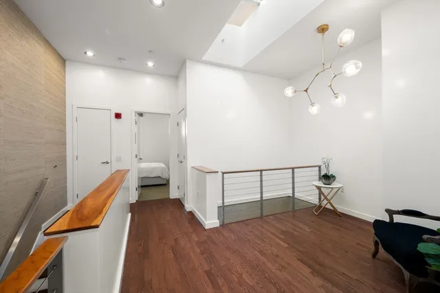 a view of hallway with wooden floor and fan