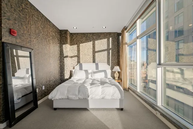 a bedroom with a bed and large window