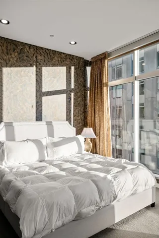 a large bed sitting in a bedroom next to a large window