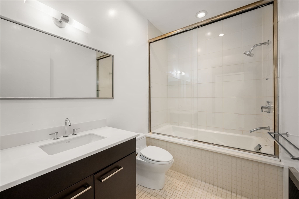 88 Kingston Street, Unit PH7C Boston, MA 02111 - Photo 23 of 31 a bathroom with a sink mirror toilet and bathtub
