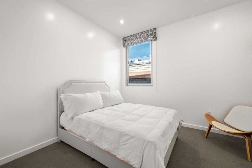 88 Kingston Street, Unit PH7C Boston, MA 02111 - Photo 24 of 31 a bedroom with a bed and a chair