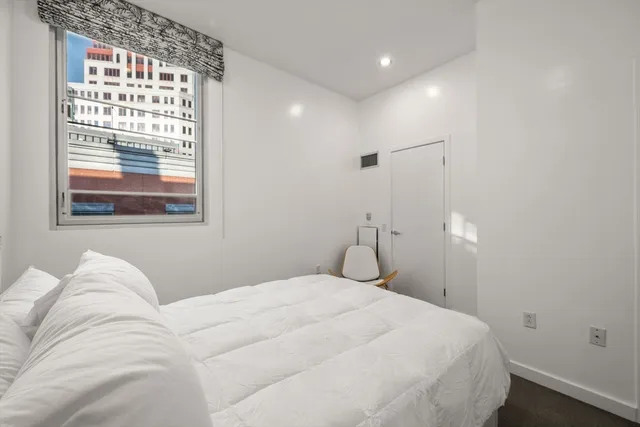 a bedroom with a large bed and a large window