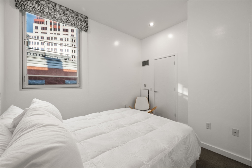 88 Kingston Street, Unit PH7C Boston, MA 02111 - Photo 25 of 31 a bedroom with a large bed and a large window
