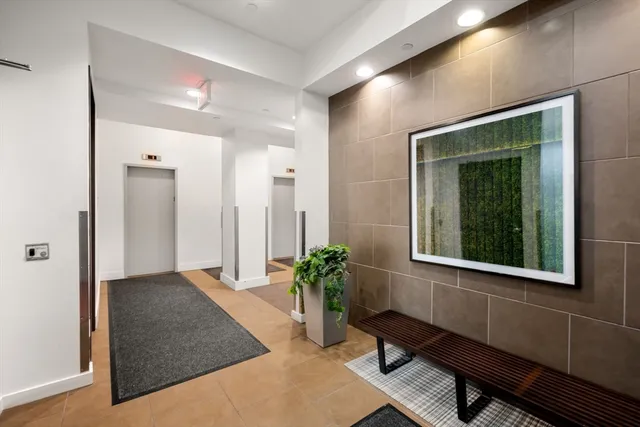 a hallway with wooden floor and a potted plant