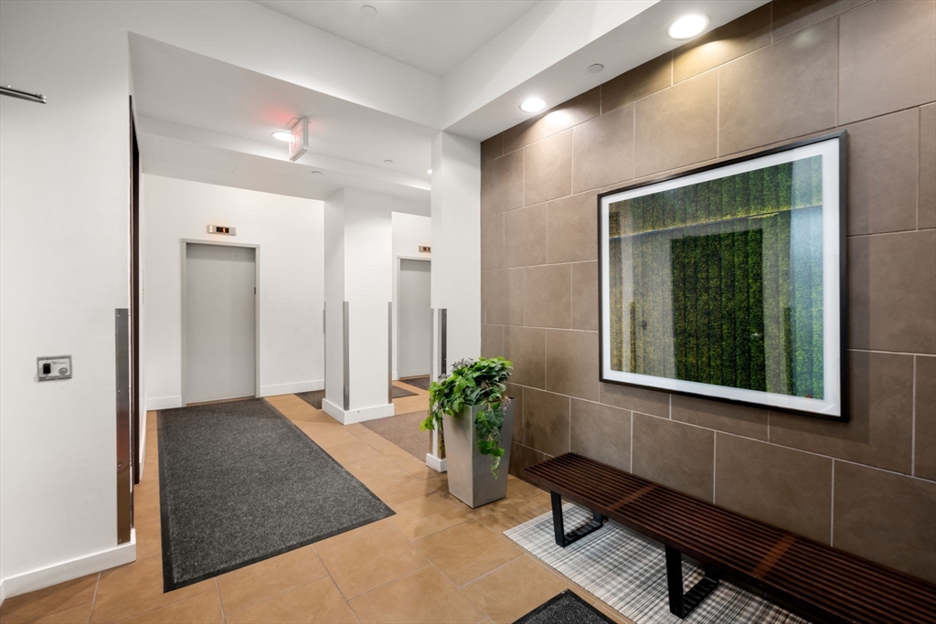 88 Kingston Street, Unit PH7C Boston, MA 02111 - Photo 30 of 31 a hallway with wooden floor and a potted plant