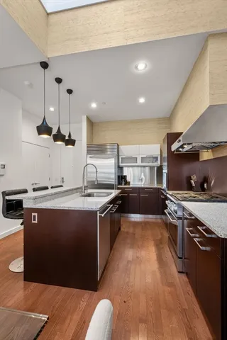 a large kitchen with stainless steel appliances a stove and a sink