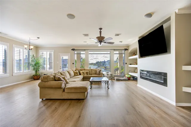 a living room with furniture ceiling fan and a wooden floor