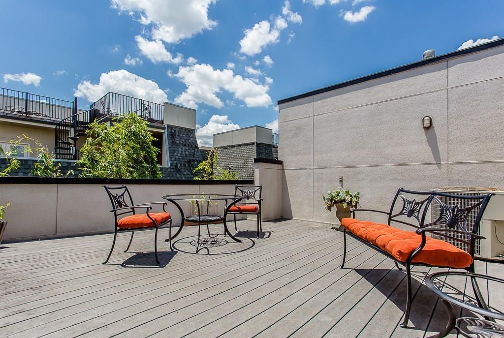 a roof deck with a table and chairs