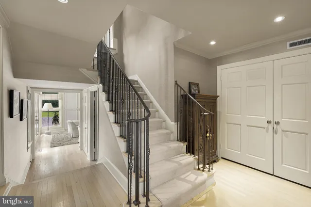 a view of a hallway with wooden floor and staircase