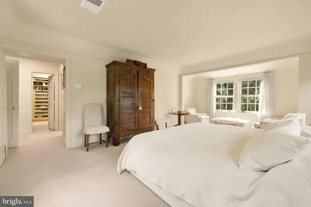 a spacious bedroom with a bed and a large window