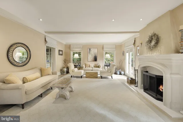 a living room with furniture a clock and a fireplace