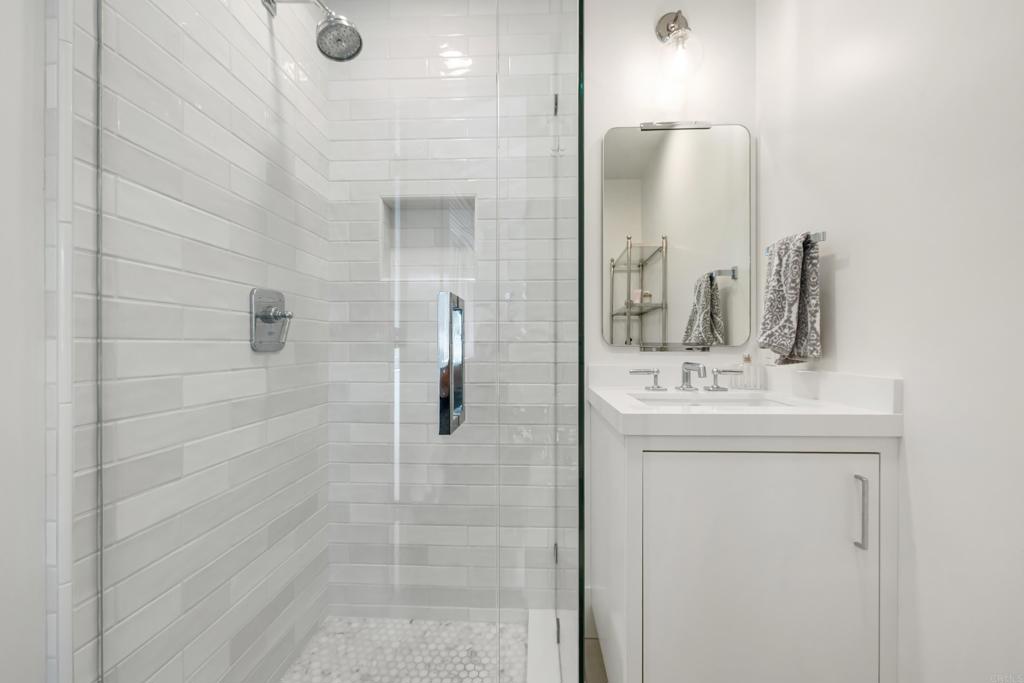 236 24th Street Del Mar, CA 92014 - Photo 23 of 44 a bathroom with a sink a mirror and shower