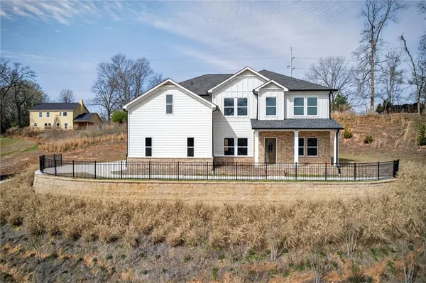 a view of house with a yard and large trees
