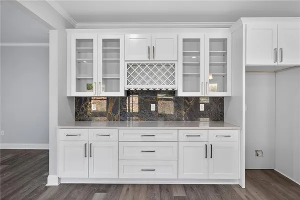 a kitchen with white cabinets and sink