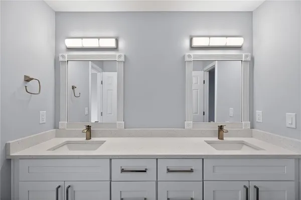 a bathroom with double vanity sink and a mirror