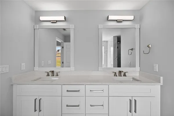 a bathroom with double vanity sinks and a mirror