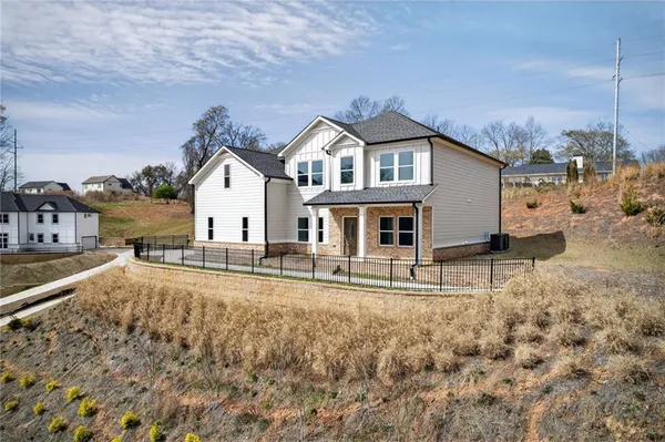 a view of a house with a yard and large trees