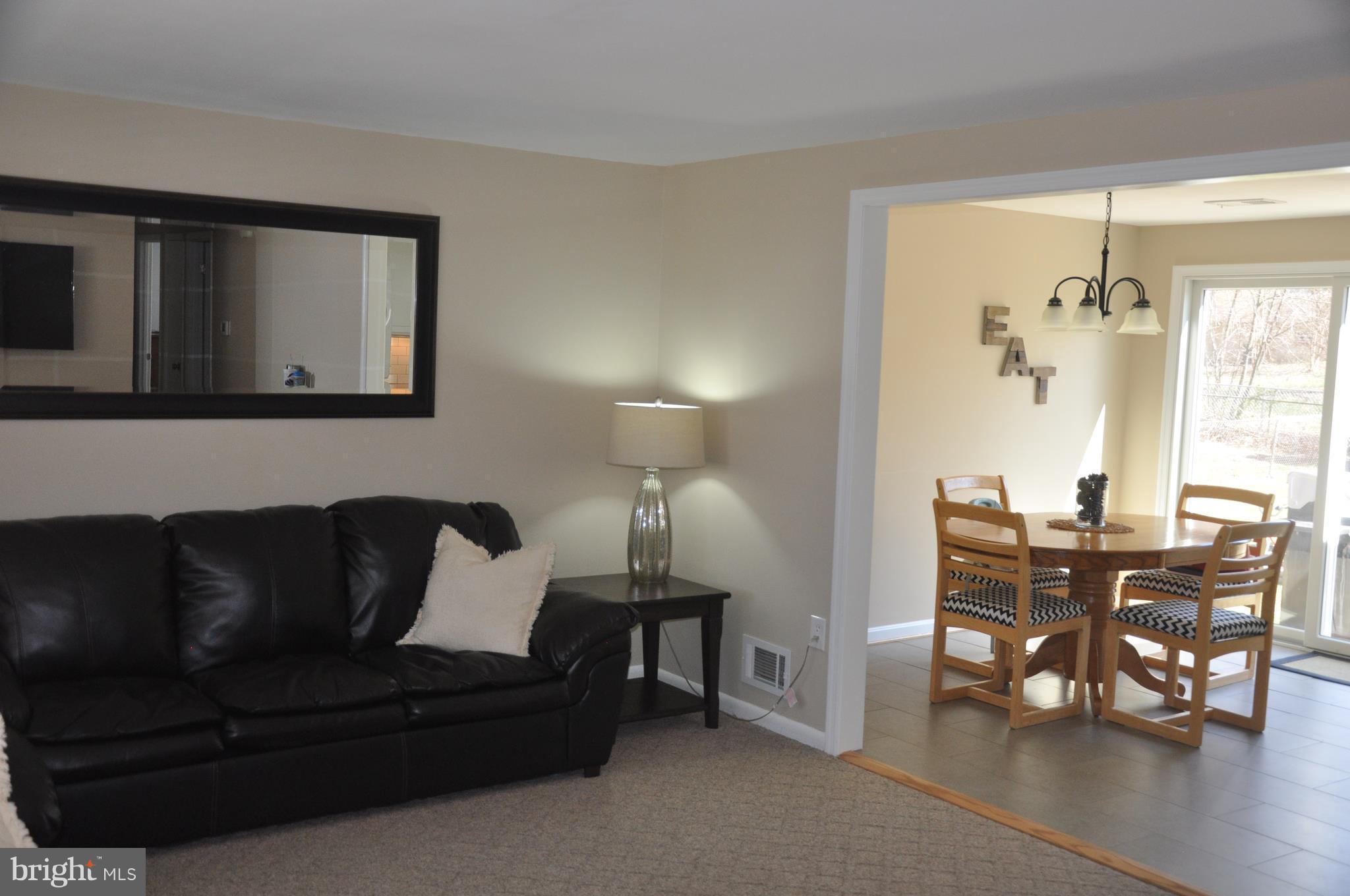 13847 Meadowbrook Road Woodbridge, VA 22193 - Photo 4 of 29 a living room with furniture and a dining table with wooden floor