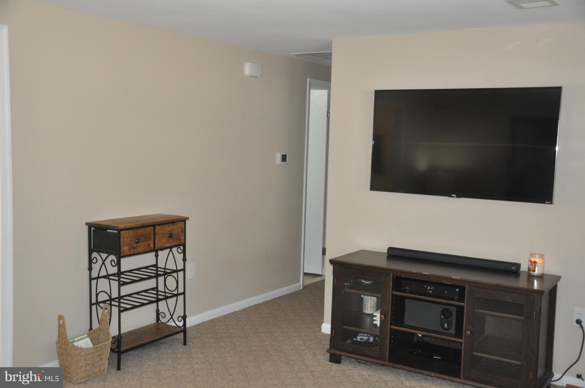 13847 Meadowbrook Road Woodbridge, VA 22193 - Photo 10 of 29 a living room with a flat screen tv on dresser and a wooden floor