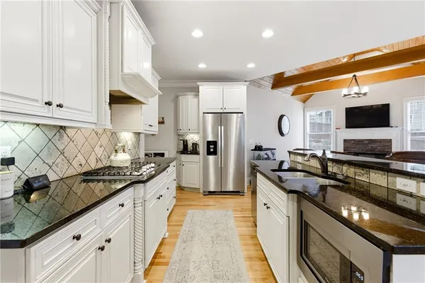 a kitchen with stainless steel appliances granite countertop a sink and a stove