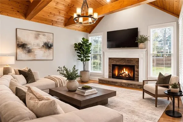 a living room with furniture a flat screen tv and a fireplace