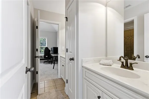 a en suite bathroom with a sink a mirror and shower