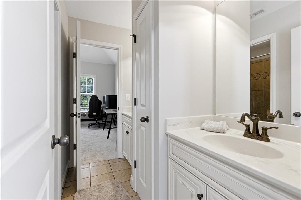810 Ravenstone Way Canton, GA 30115 - Photo 35 of 51 a en suite bathroom with a sink a mirror and shower