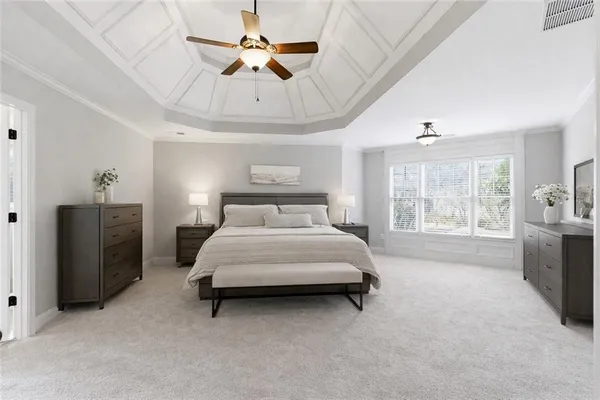 a spacious bedroom with a bed dresser and a window