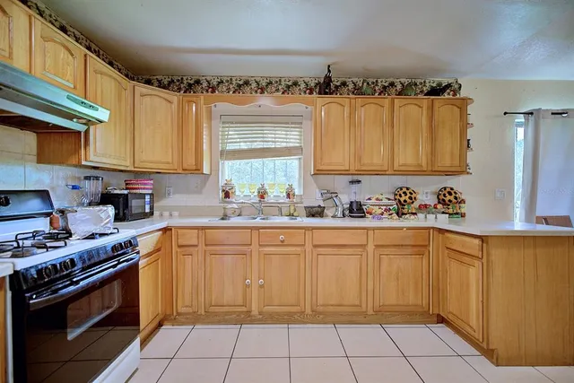 a kitchen with a cabinets a sink and a stove top oven