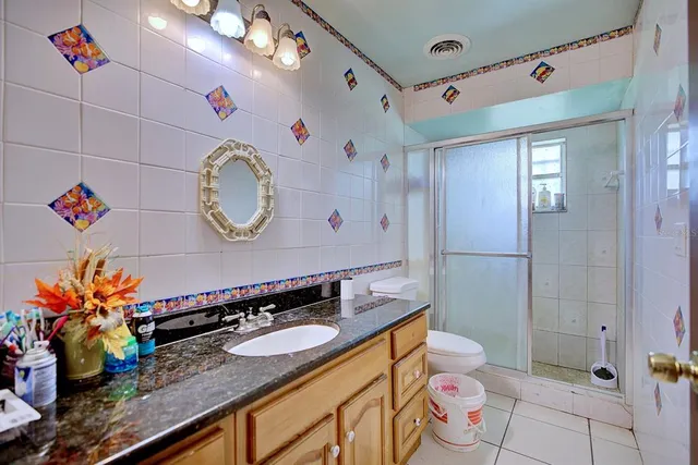 a bathroom with a granite countertop sink mirror vanity and toilet