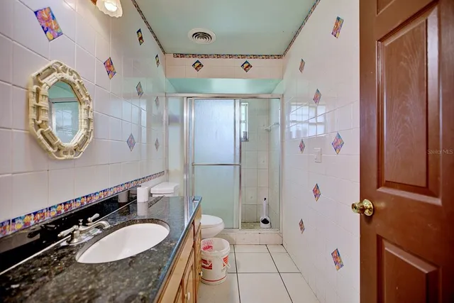a bathroom with a granite countertop double vanity sink and a mirror