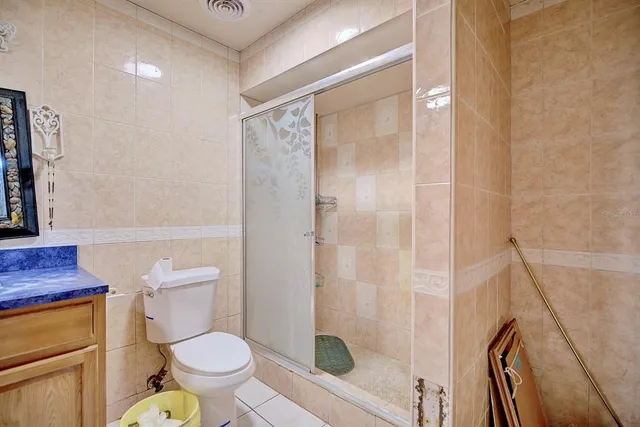 a white toilet sitting next to a bathroom sink and a shower