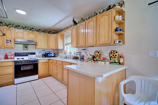 a kitchen with stainless steel appliances granite countertop a sink dishwasher stove top oven and cabinets