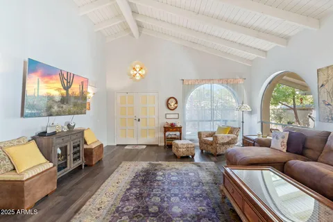 a living room with furniture a flat screen tv and a large window
