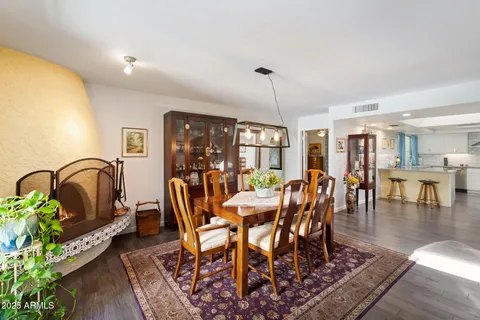 a dining room with furniture a potted plant and wooden floor